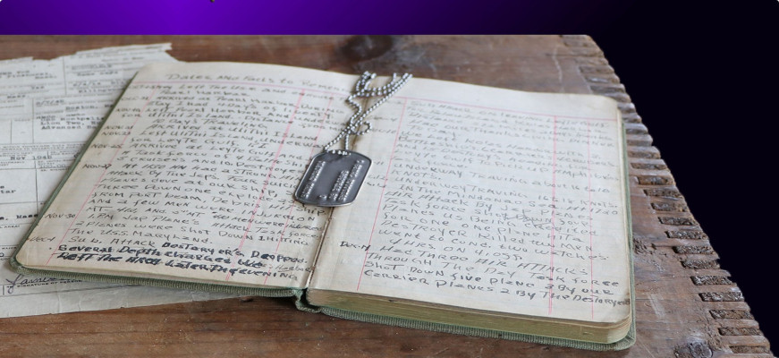 Military dog tags on top of a soldier's open handwritten diary.
