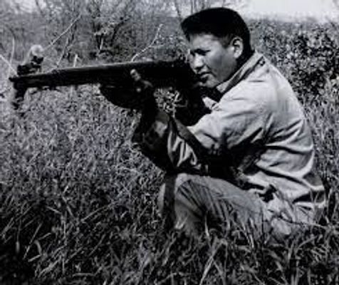 Chester Nez firing a rifle during WWII. Press Enter to Activate this item.