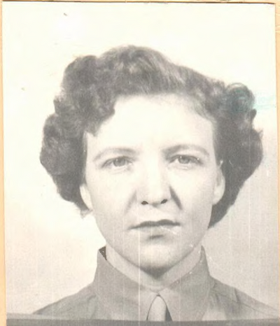 A young woman in a Marine Corps uniform with short, curled hair.