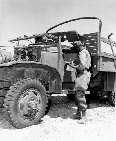Pearl Mack, Jr.'s using a device next to a military truck.